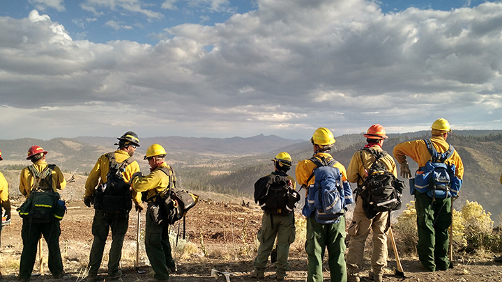 Louis’ crew examines hot spots to prevent fire reigniting. Members carry heavy packs all day — 12 hours — while fighting fires.