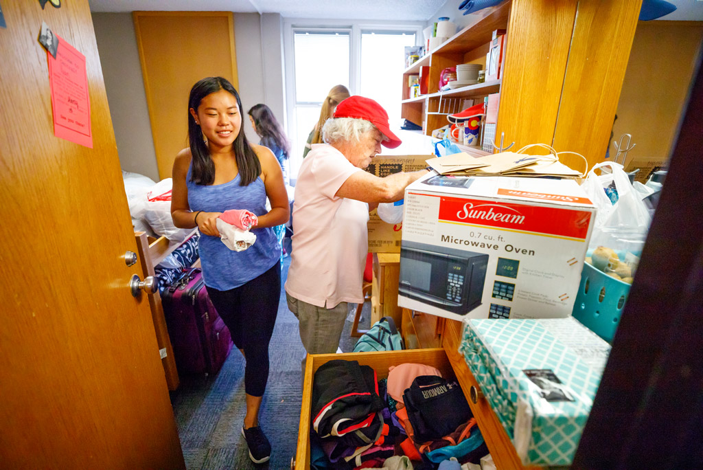 Student unpacking and organizing her new room.