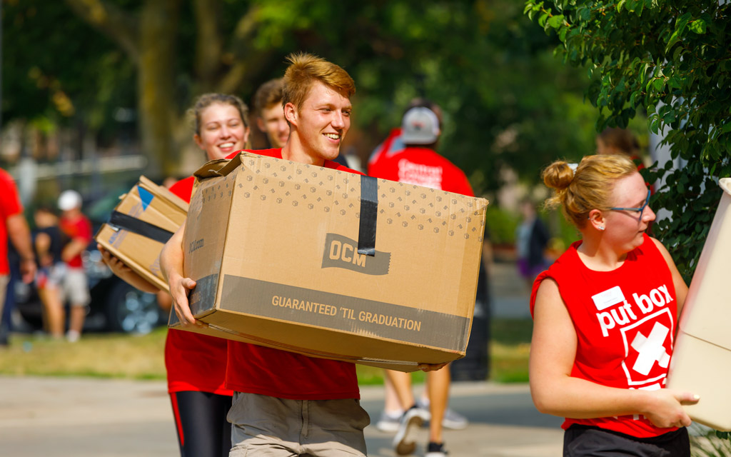 Student volunteers moving boxes