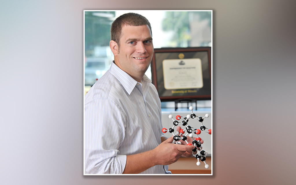 Jay Wackerly holding a model of the cambiarene molecule.