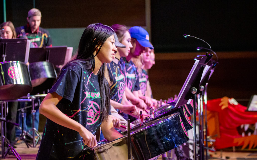 Members of the Steel Pans Drum Band performing during a concert
