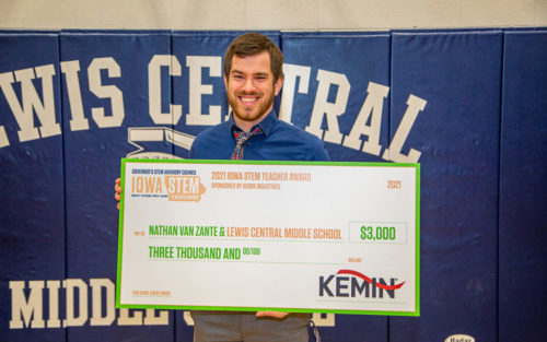 Nathan Van Zante, science teacher at Lewis Central Middle School, holds an oversized check after being awarded the 2021 STEM Teacher Award by Deb Frazee, Southwest Region STEM manager.