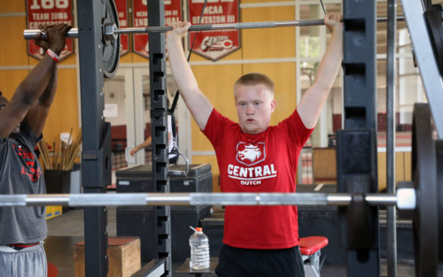 A Central College student-athlete lifting weights.