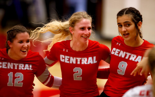 Lauren Brown ’24 celebrates with two of her teammates during a Central College volleyball match.