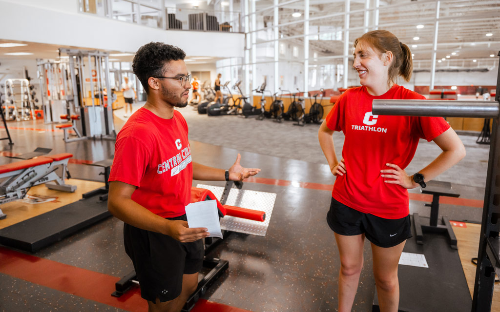 Male strength and conditioning student works with female triathlon athlete