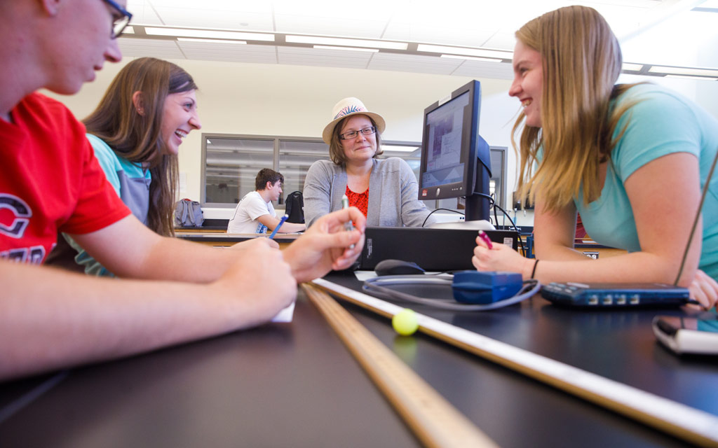 Professor with students working on a computer