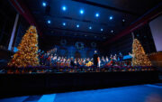 Wide angle photo of Douwstra Auditorium with choir and Christmas trees