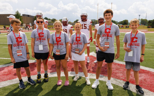 Six young students standing on the football field.