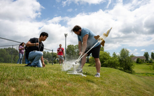 Two students launching water rockets.