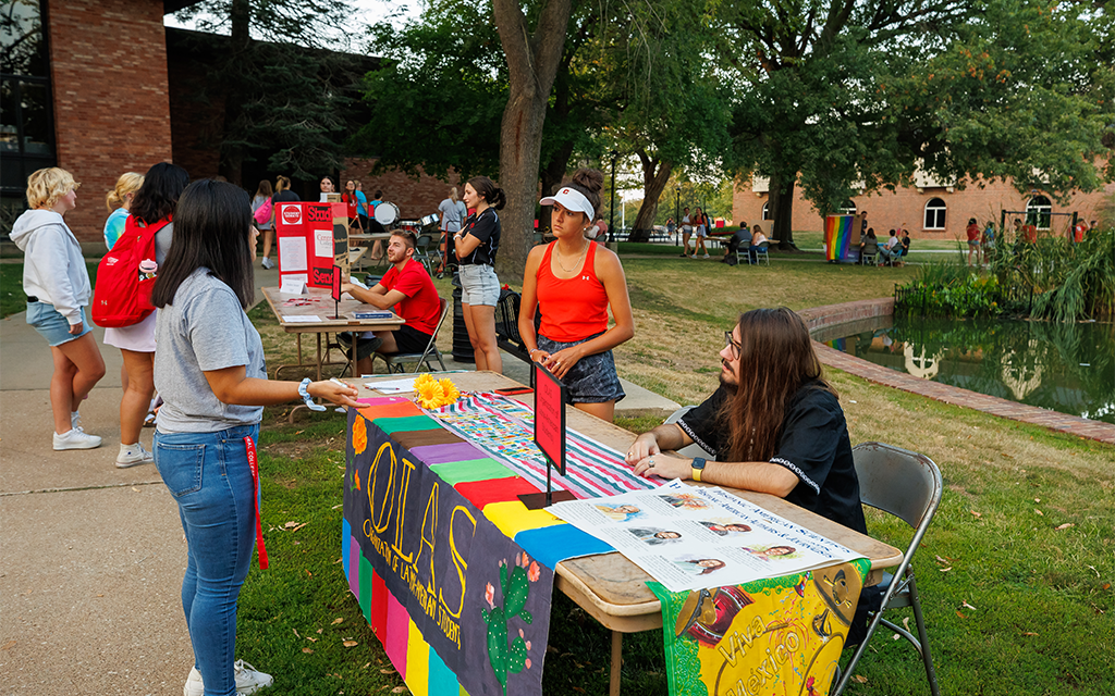 Students talking at club fair around the pond