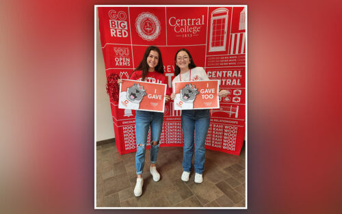 Jenna Hernandez and Cassie Elliott holding signs that read I gave and I gave too.