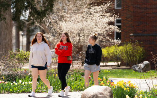 Three women walking across campus.