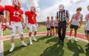 Referee with Kid Captains and football players tossing the coin.