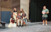 A scene from rehearsal with the Cratchit family and Mr. Scrooge.